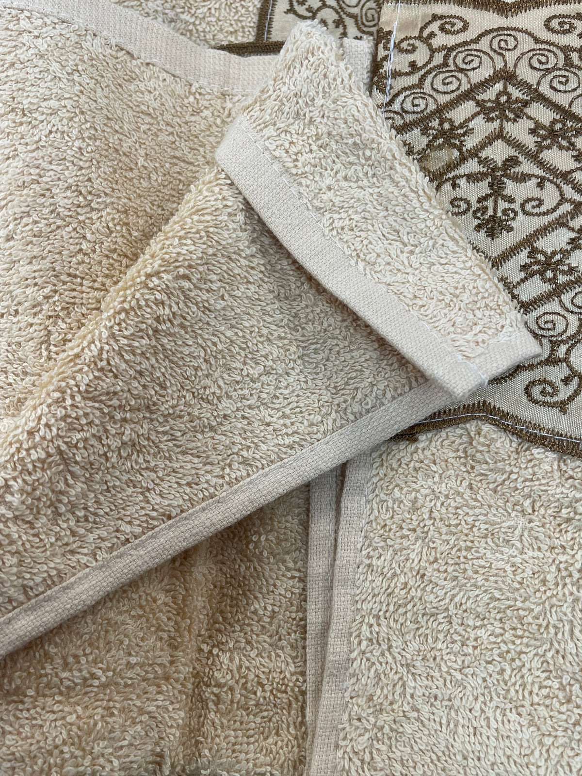 Vivian Beige 3-piece towel set — champagne beige plush bath towel, hand towel and washcloth with antique gold baroque lace embroidered border, styled on warm bathroom vanity