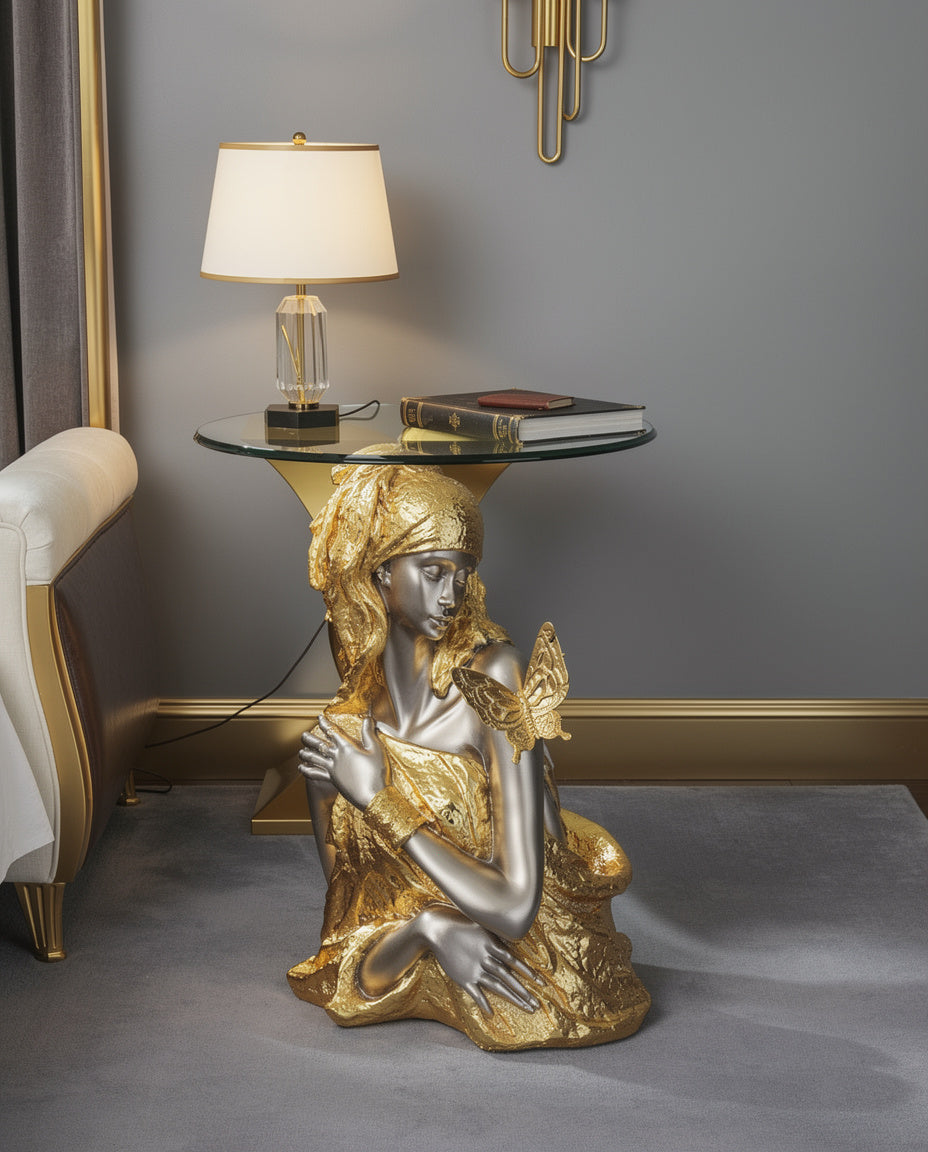 Gold & Silver Butterfly Goddess Sculptural Glass Side Table lifestyle — 25 inch seated gold goddess with crystal table lamp on 16.5 inch glass top in elegant golden and grey luxury bedroom corner