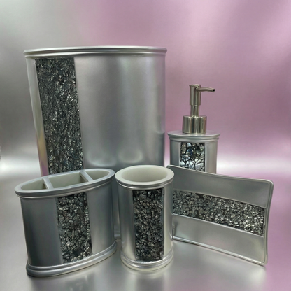 Sinatra Silver accessories set — luminous silver crushed mosaic 5-piece vanity collection on silver-grey marble counter beside pink orchids and coordinating silver rugs