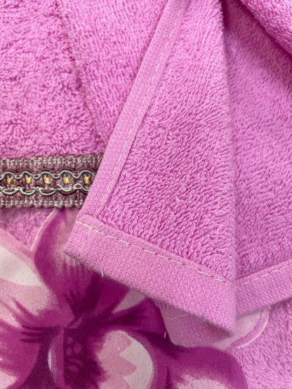 Lily Purple towels displayed on marble vanity — rose purple bath towel, hand towel and washcloth with jeweled orchid trim beside matching accessories and orchid flowers
