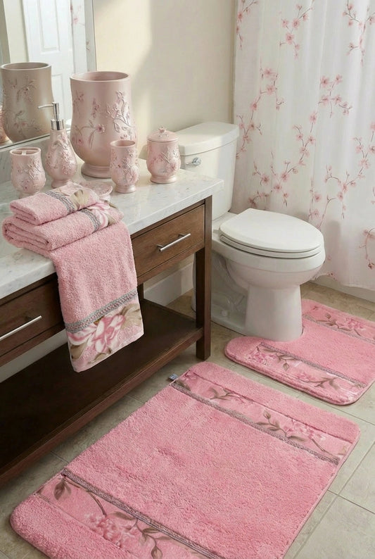 Melrose Pink shower curtain — soft blush sheer panel with delicate cherry blossom branch motif beside pink ceramic accessories, pink towels, bath rug and contour rug in warm bathroom