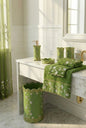 Chateau Green full bathroom styled — sage green window curtain, accessories, towels, rugs and bath at golden sunset